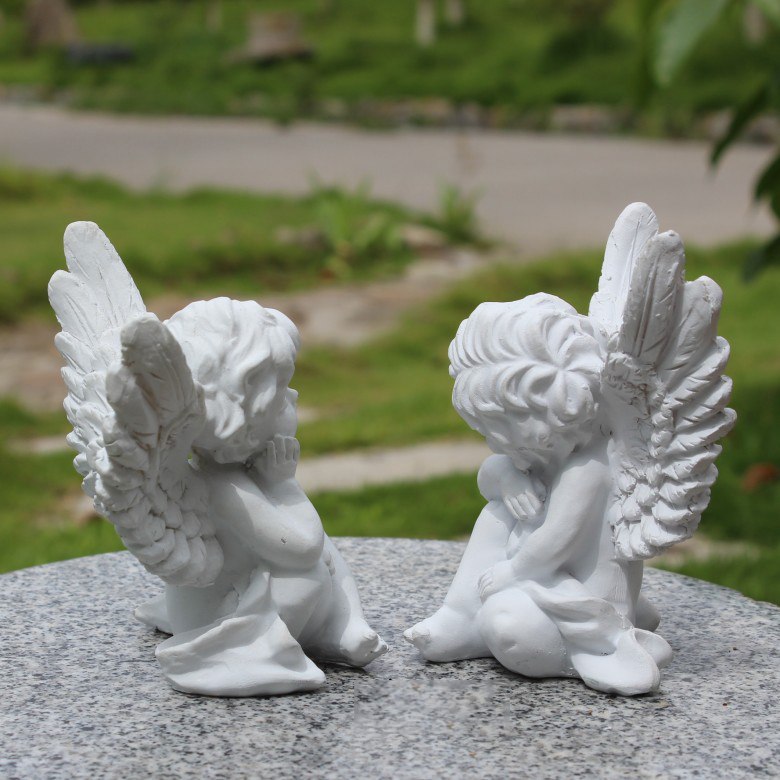 子供の天使置物のエンジェル人形、翼を広げ胡坐を組んで座って目を瞑っ